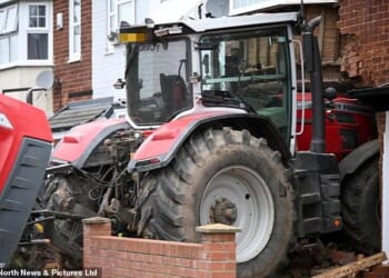 A stolen tractor smashed into a house before a masked gang fled the scene in a getaway car
