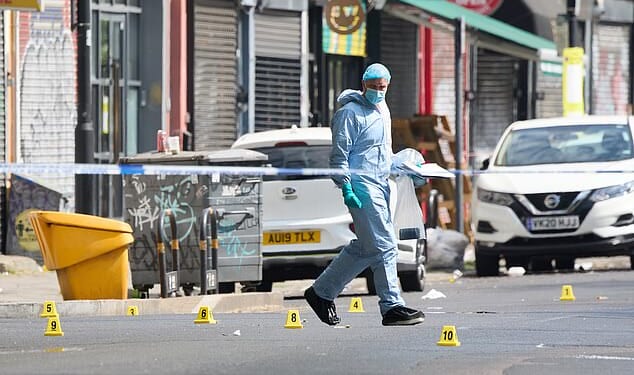 Investigators wearing blue overalls, masks and gloves inspected the scene on Coldharbour Lane in Brixton, south London