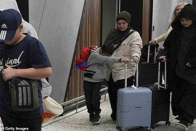 Ms Ahmad was seen holding tightly onto her youngest son while leaving Melbourne Airport on Thursday night