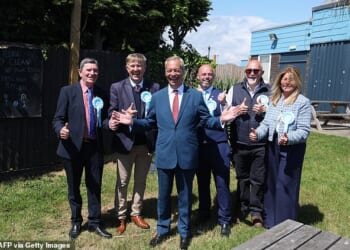 Reform UK leader Nigel Farage poses with local candidates in a pub garden in Jaywick, near Clacton-on-Sea, eastern England on May 7, 2026. UK polling stations opened on May 7 in local elections set to heap more pressure on beleaguered Labour Prime Minister Keir Starmer and showcase the rise of hard-right and left-wing populists. (Photo by Chris Radburn / AFP via Getty Images)