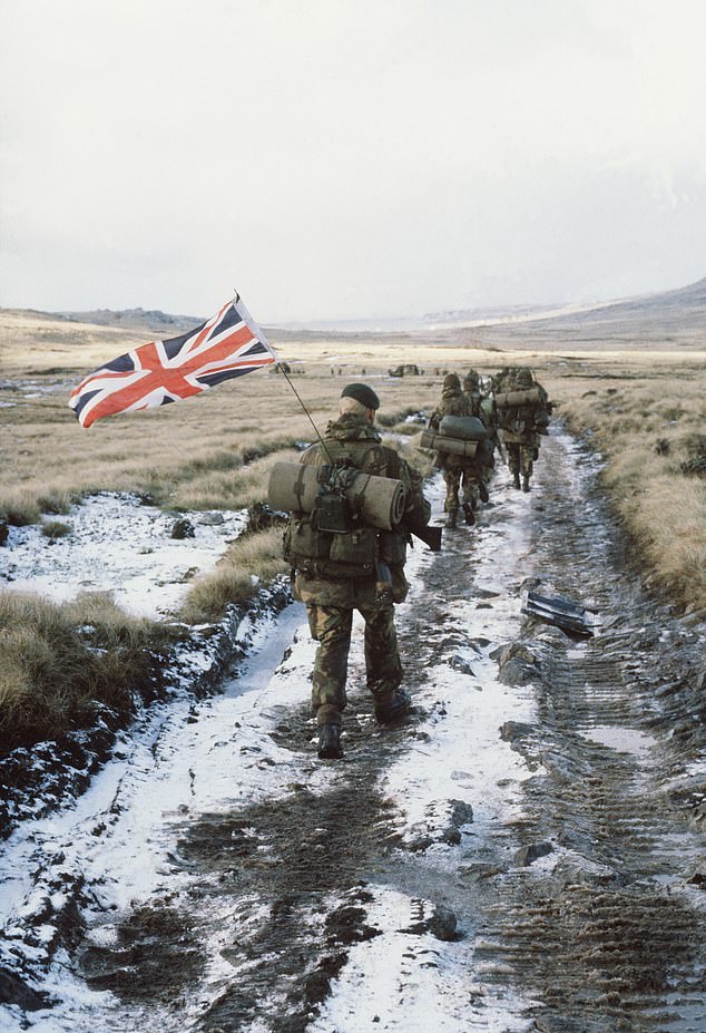 Royal Marine Peter Robinson carrying the Union Jack as he marched towards Stanley in the final hours of the Falklands War in June 1982